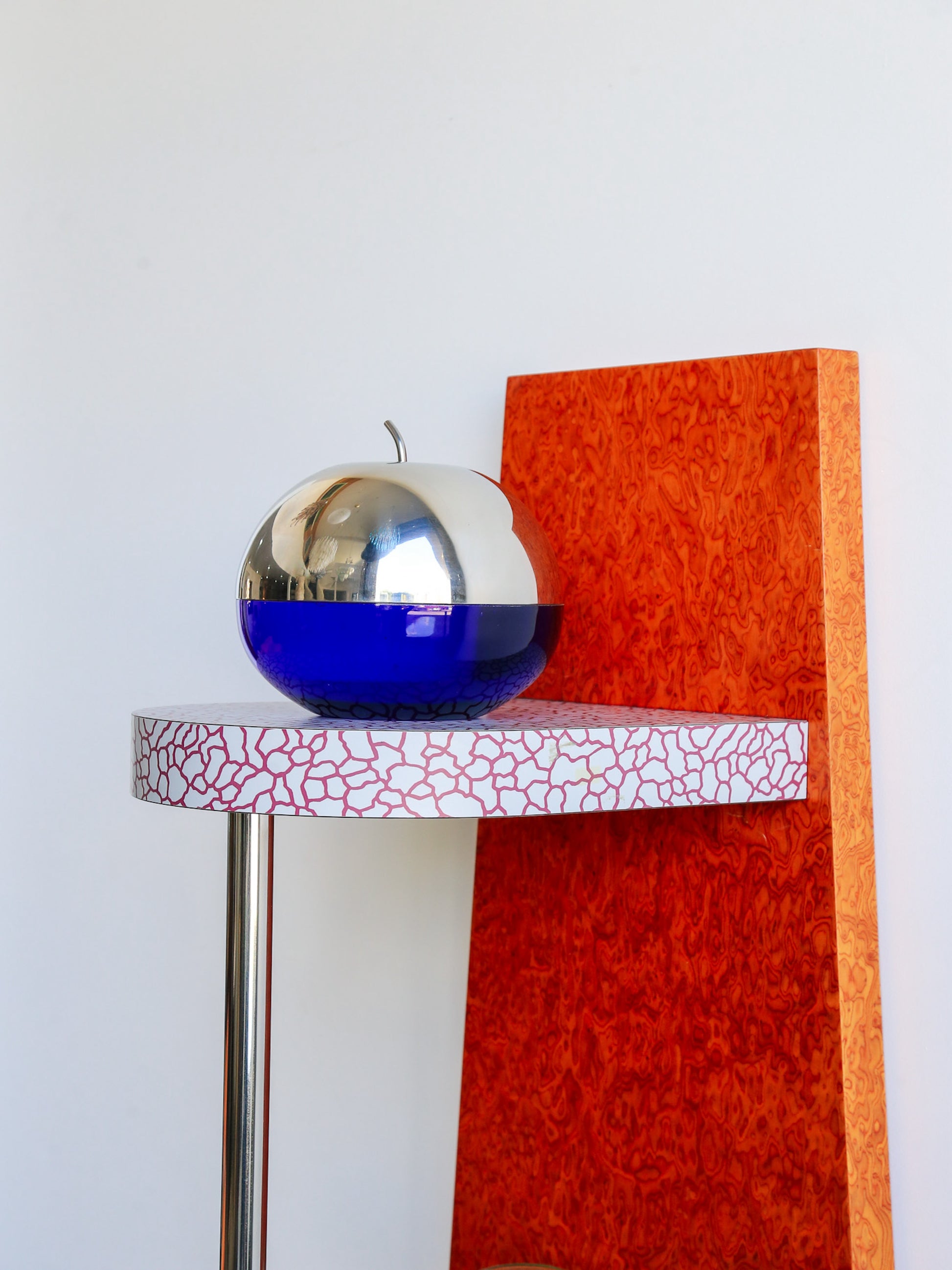 Decorative object on a small round table with a textured surface against a plain background