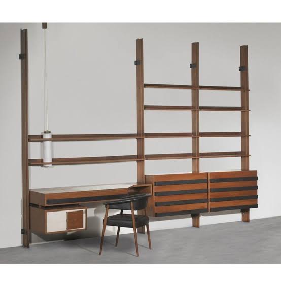 Wooden wall unit with shelves and a desk against a plain background by Gastone Rinaldi 