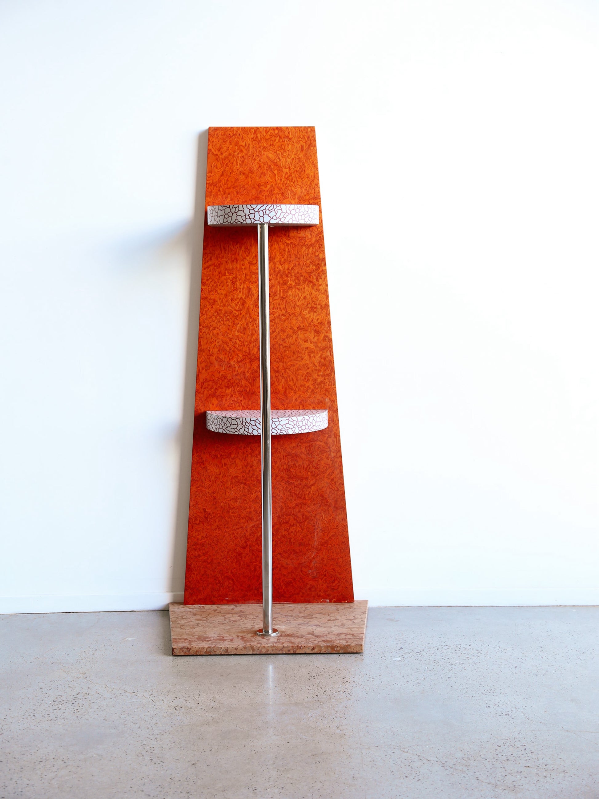 Shelf by sottass in orange laminate and marble base in red with a chrome pole supporting the top shelf