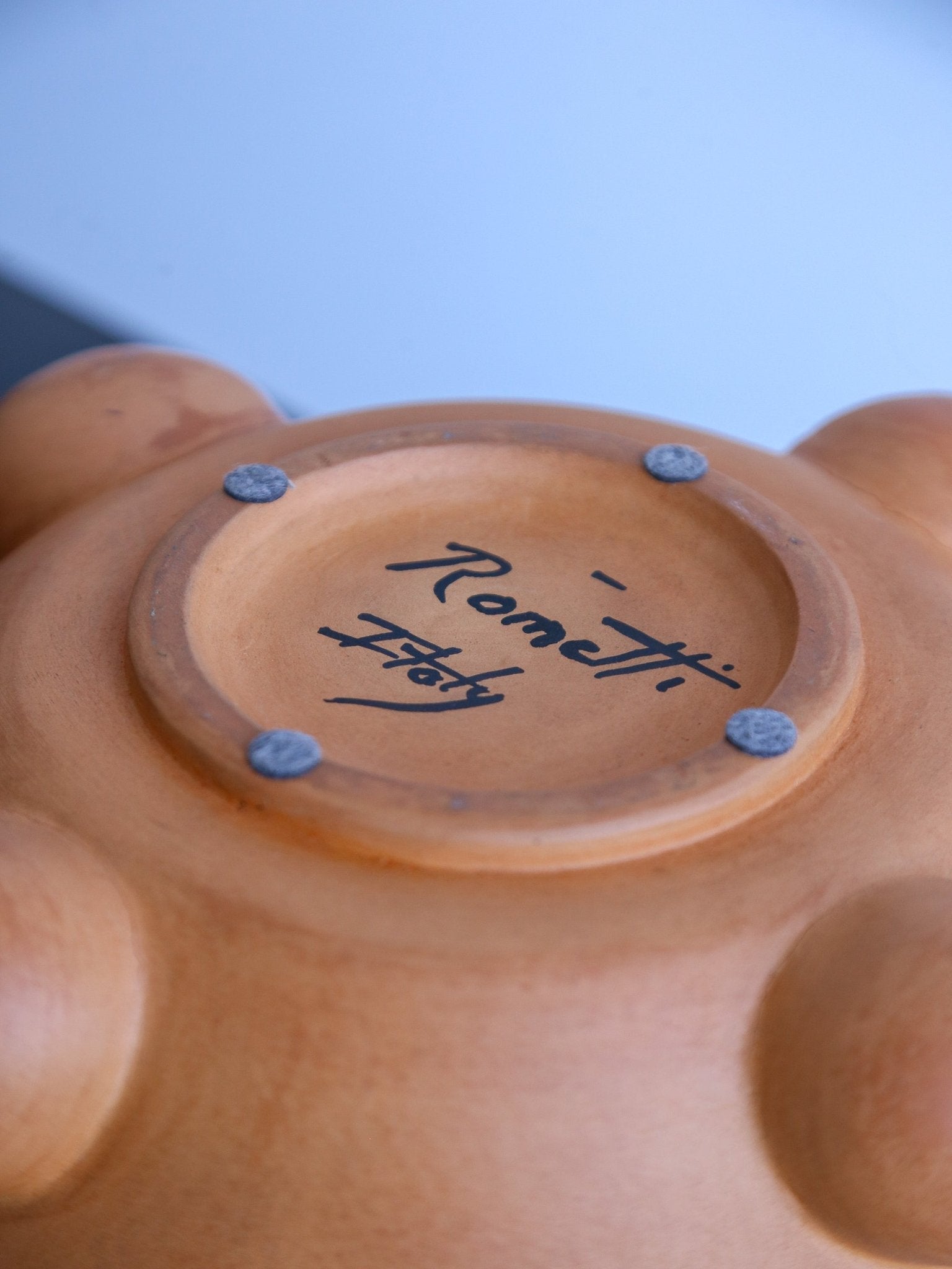 Ceramic product with 'Rometti Italy' branding on a blurred background