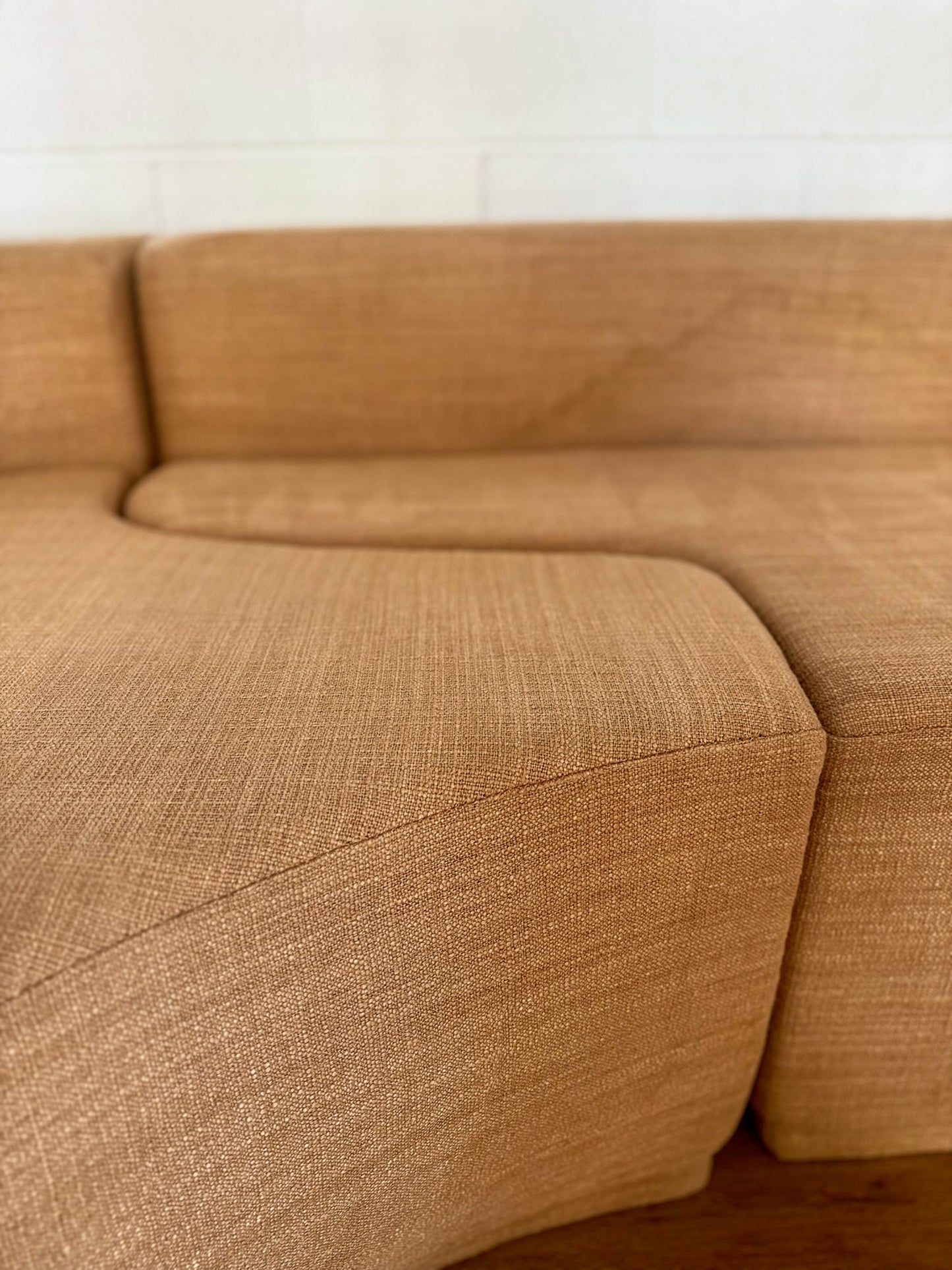 Brown sectional sofa against a white wall