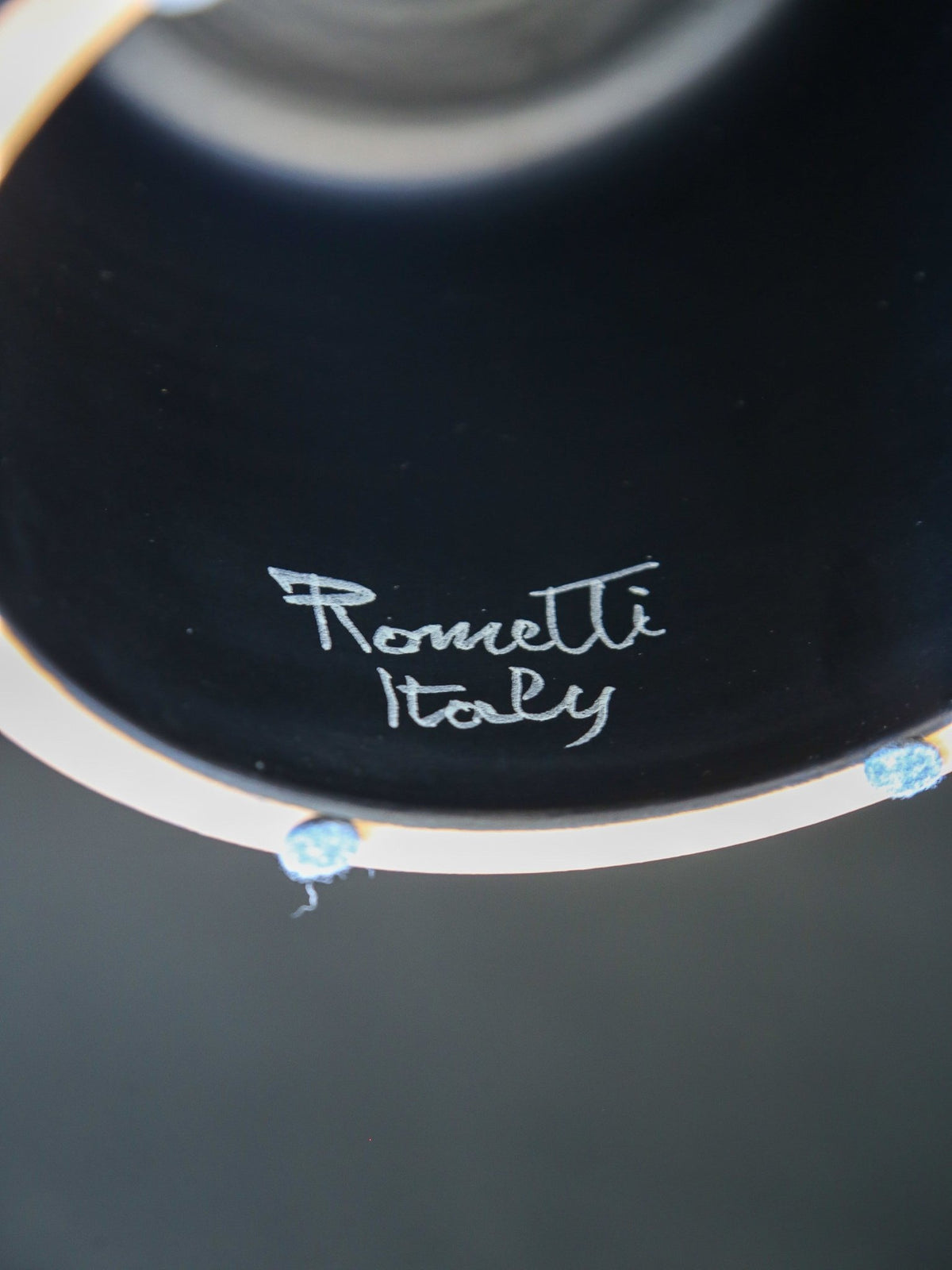 Close-up of a black dish with 'Romantti Italy' branding.