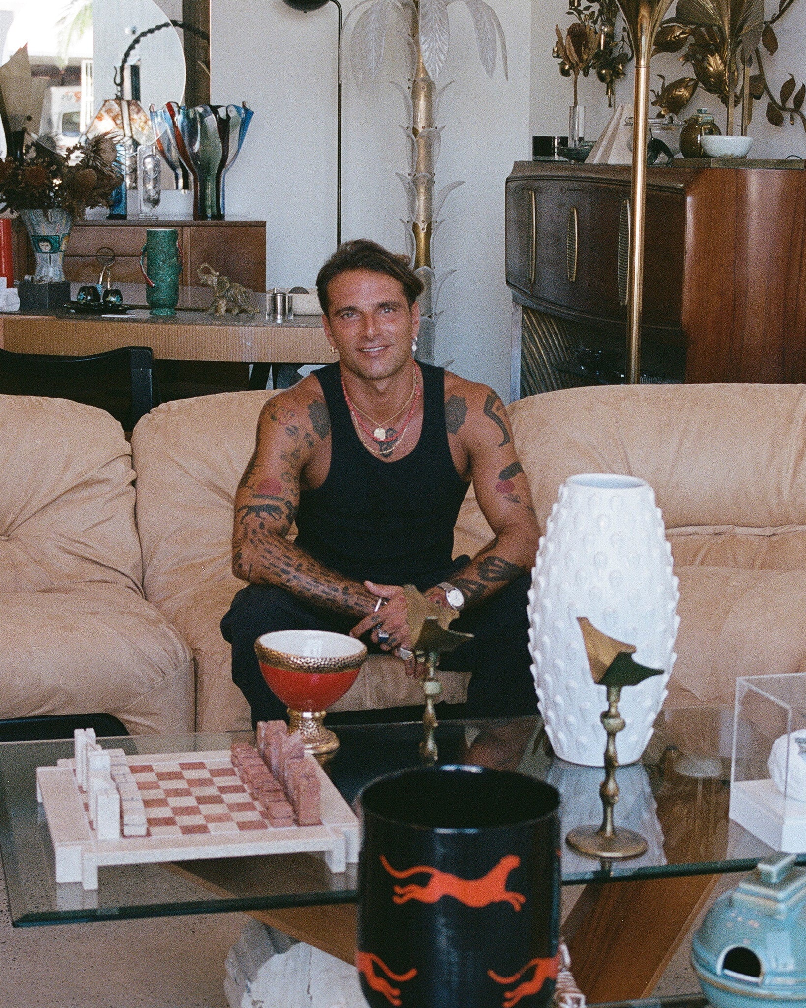 Man sitting on a couch in a living room with decor and furniture.