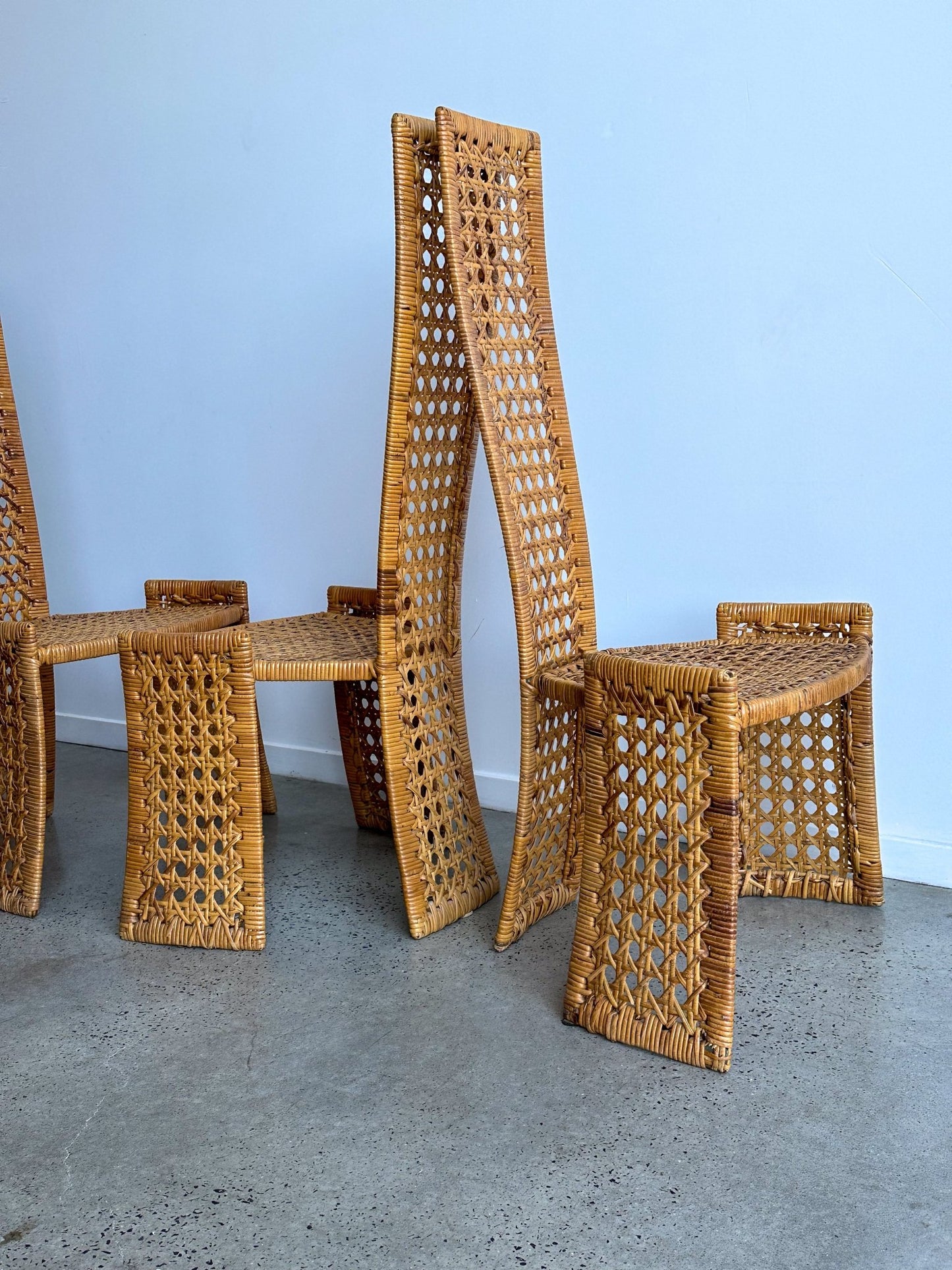 Set of wicker chairs against a light blue wall.