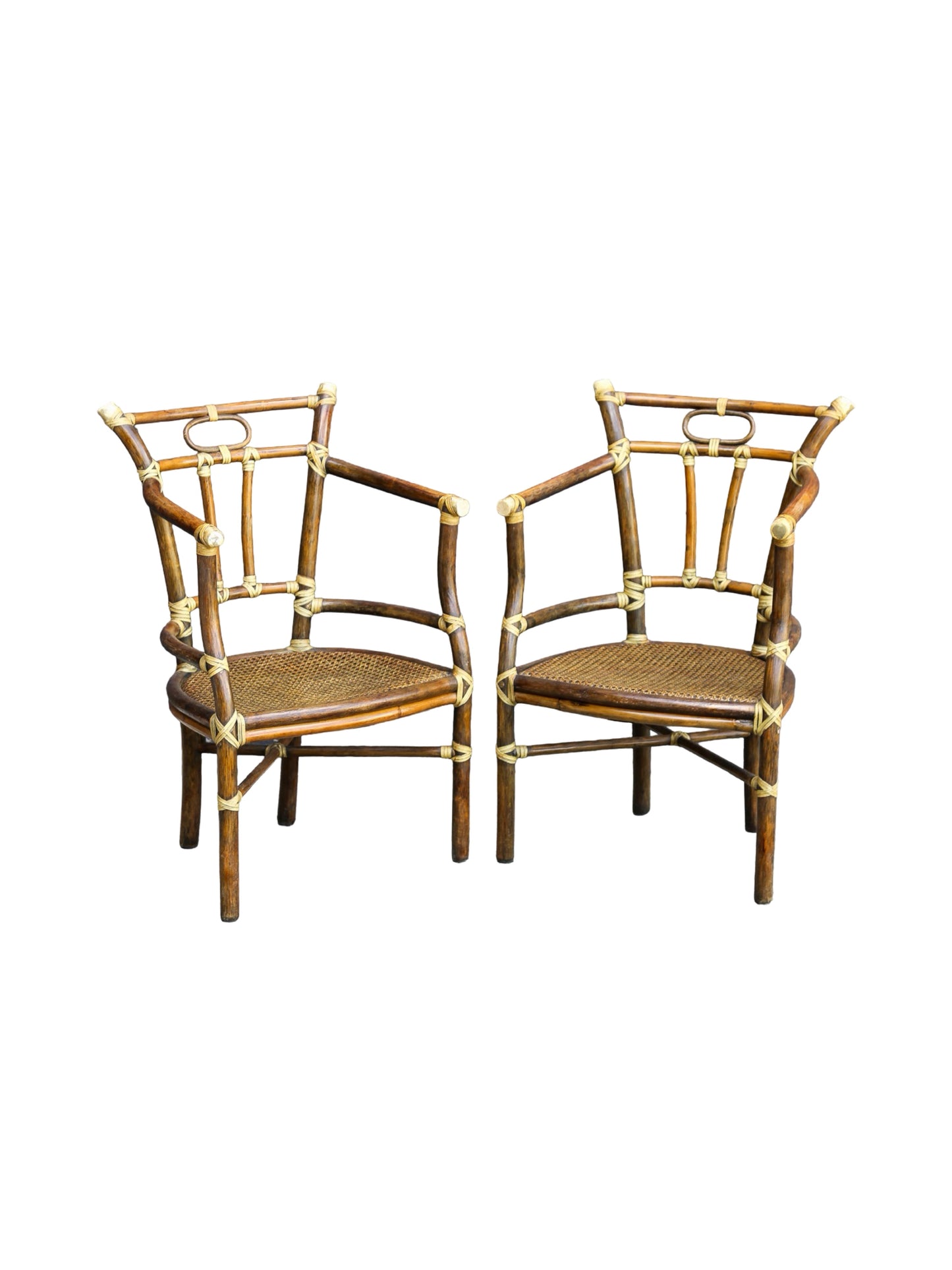 Two matching bamboo armchairs with woven cane seats and brass hardware, shown side by side on a plain white background.