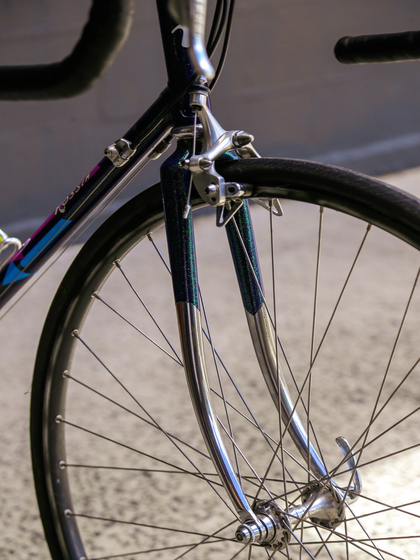 Close-up of a bicycle's front wheel and frame with a blurred background