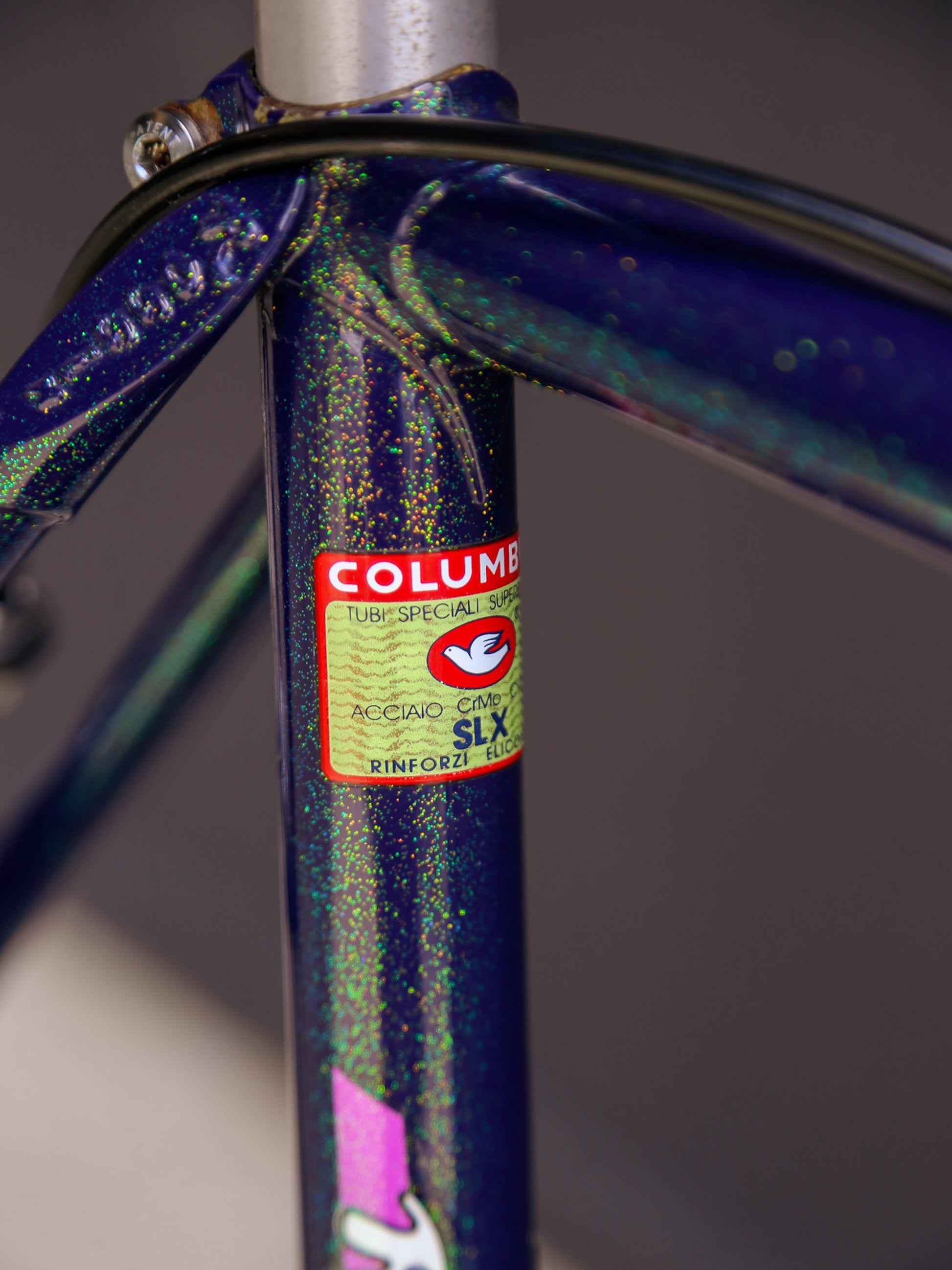 Close-up of a bicycle frame with Columbus branding on a blurred background