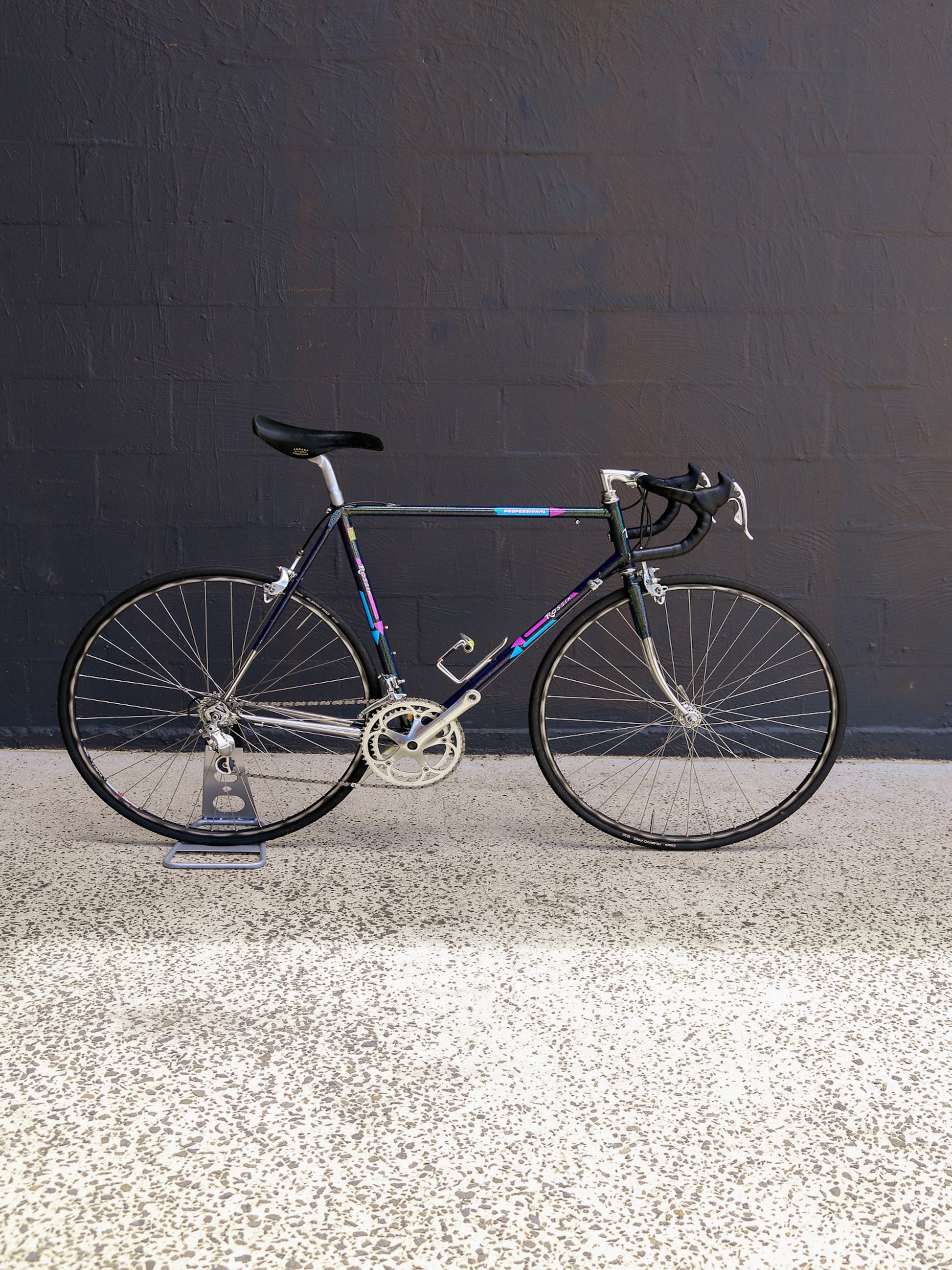 Racing bicycle on a reflective surface with a dark wall background