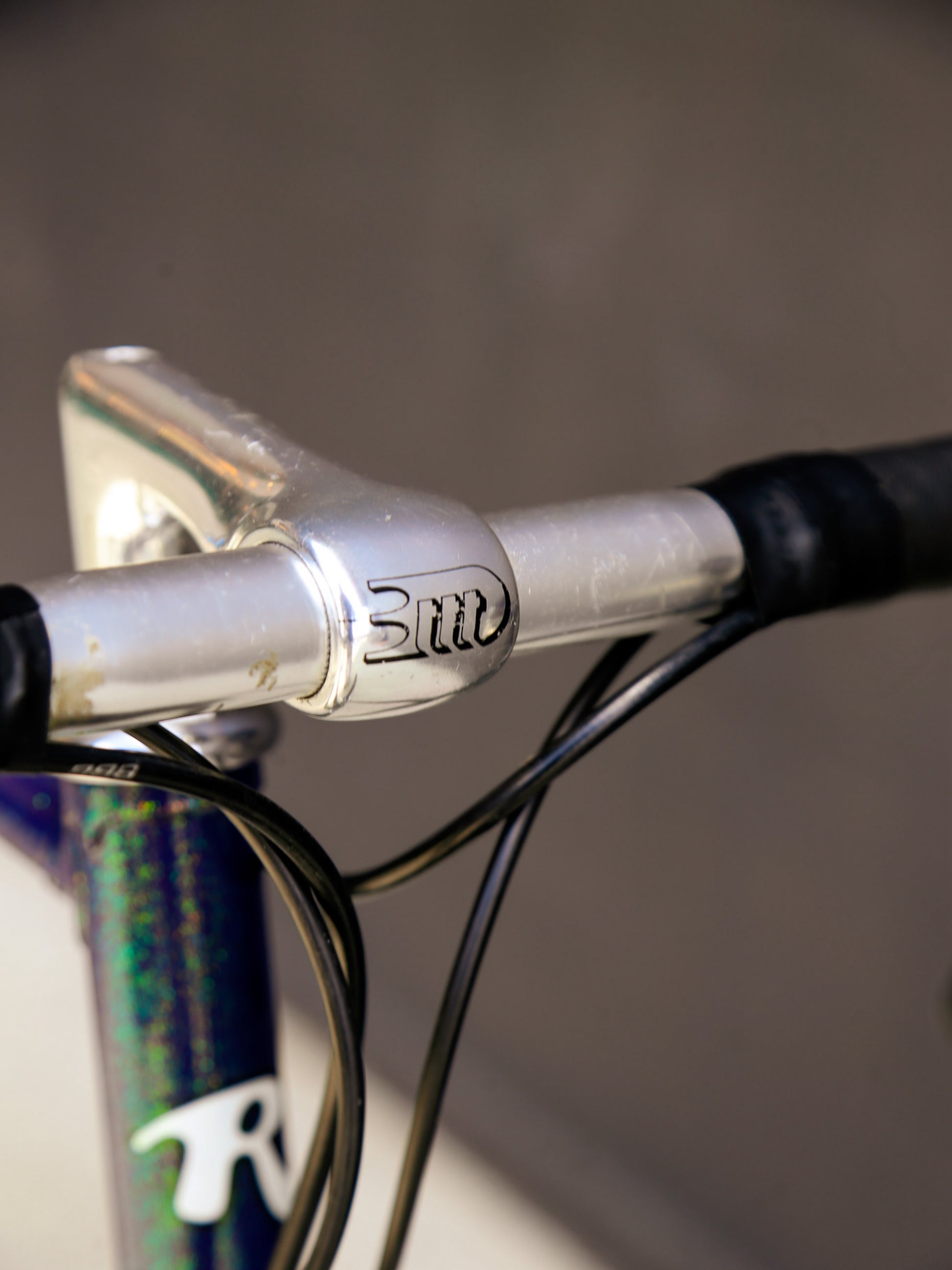 Close-up of a bicycle handlebar with 'Rossin' branding on a blurred background