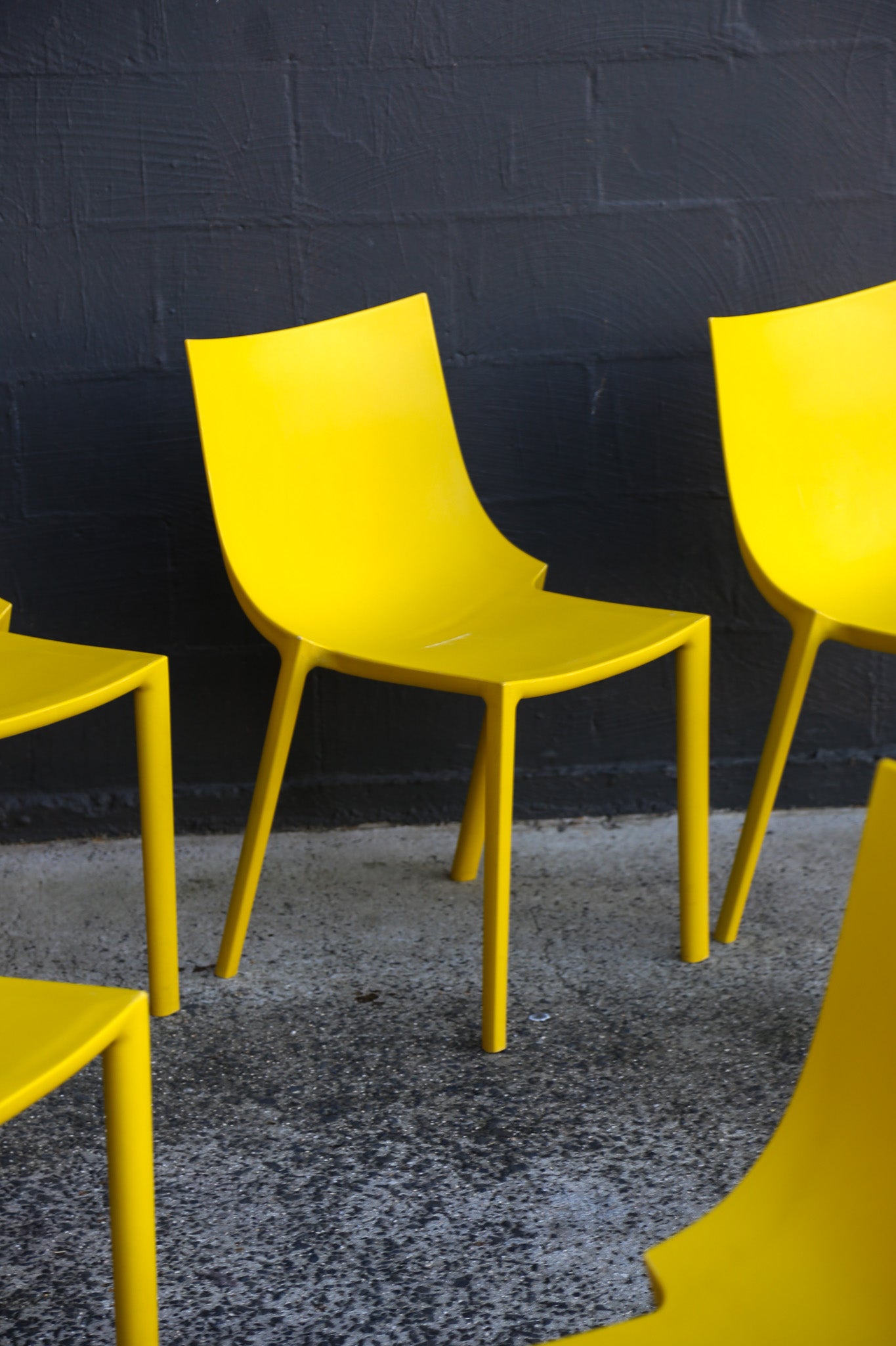 Yellow chairs against a dark textured wall.