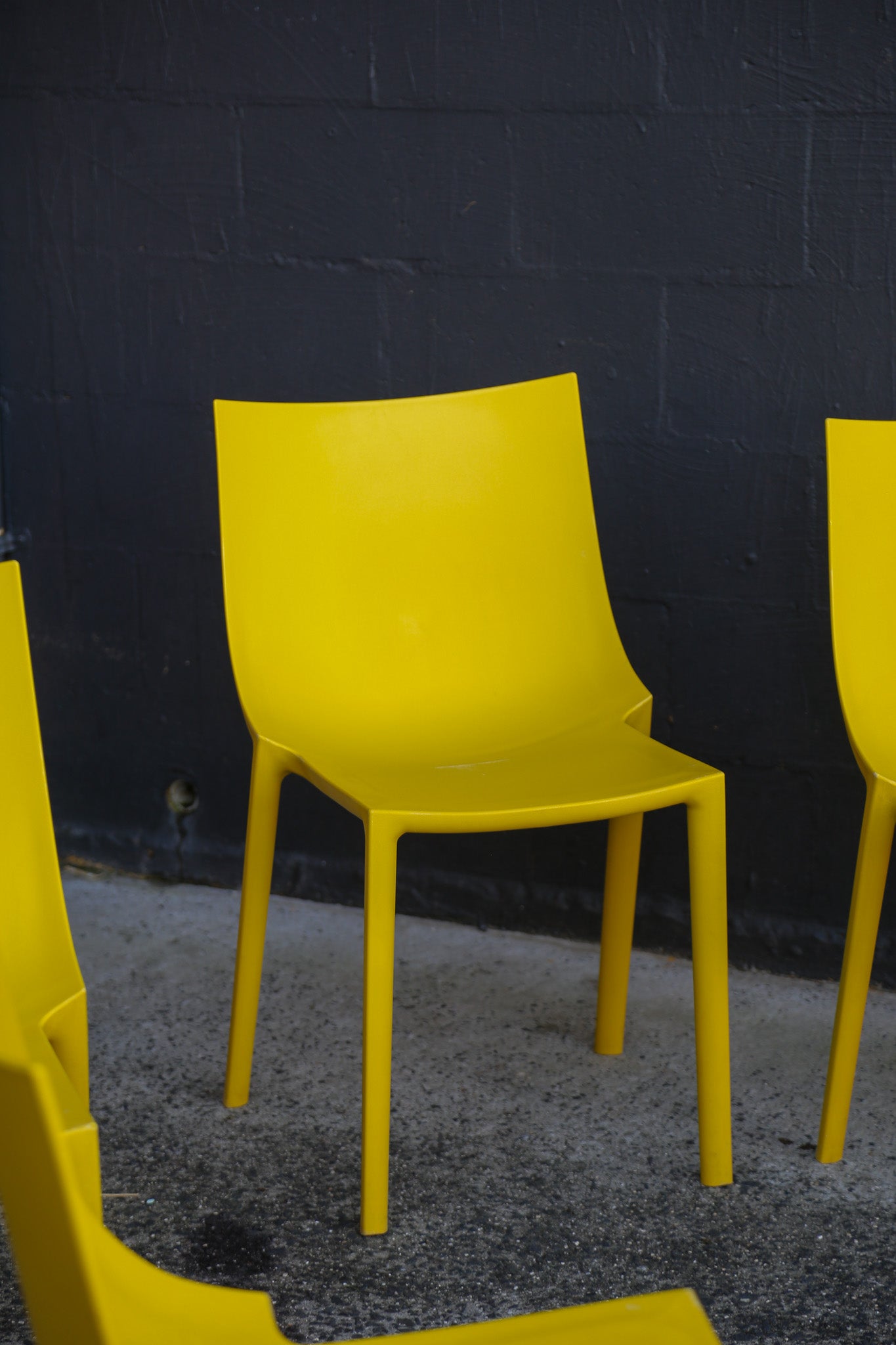 Yellow chairs against a dark brick wall.