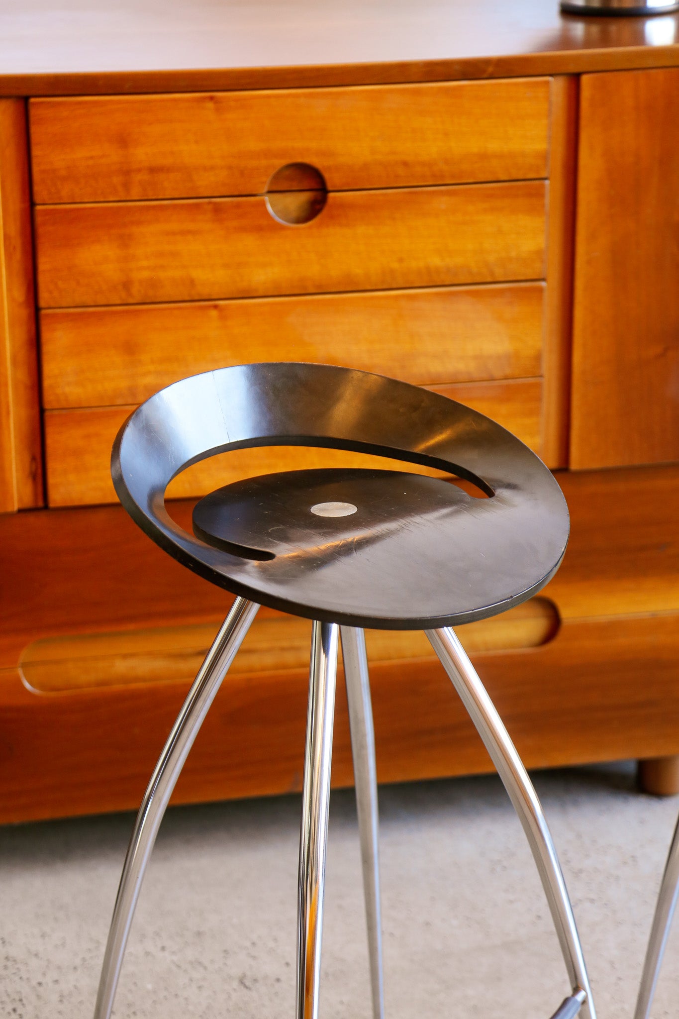 Metal stool with a wooden cabinet in the background